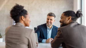A financial professional meets with two of his team members in his office to talk about strategies to grow his retirement practice.