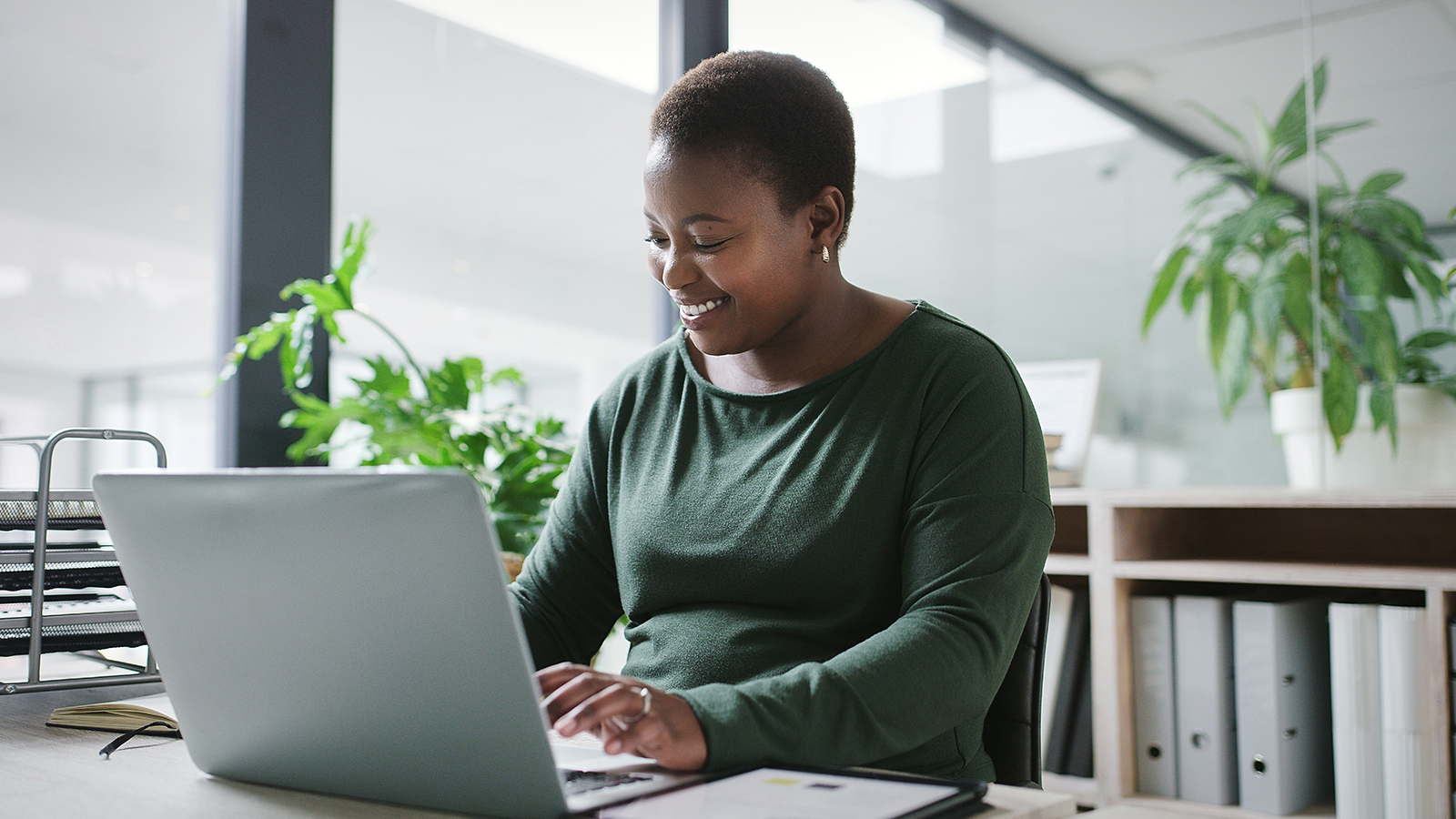 A woman reviews her employer-sponsored retirement plan on her laptop and reviews simple steps she can take to help boost her plan.