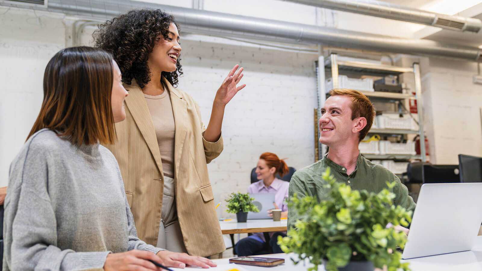 Employees collaborate in a modern office environment, reflecting how a supportive workplace experience can contribute to long-term employee retention.