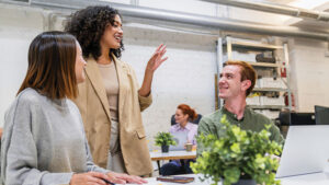 Employees collaborate in a modern office environment, reflecting how a supportive workplace experience can contribute to long-term employee retention.