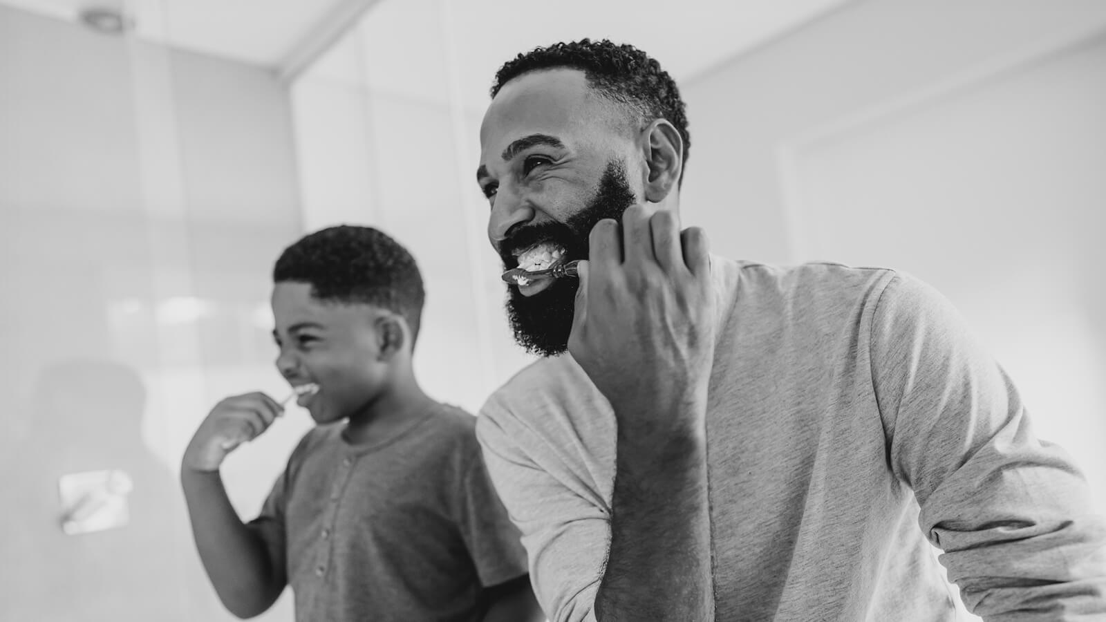 Father and child brushing their teeth.