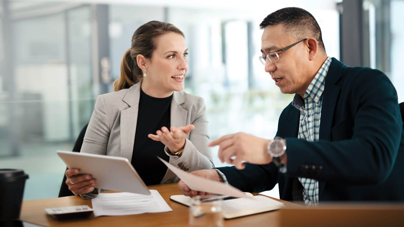 A business owner meets with her financial professional to discuss taxes for selling her small business.