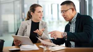 A business owner meets with her financial professional to discuss taxes for selling her small business.