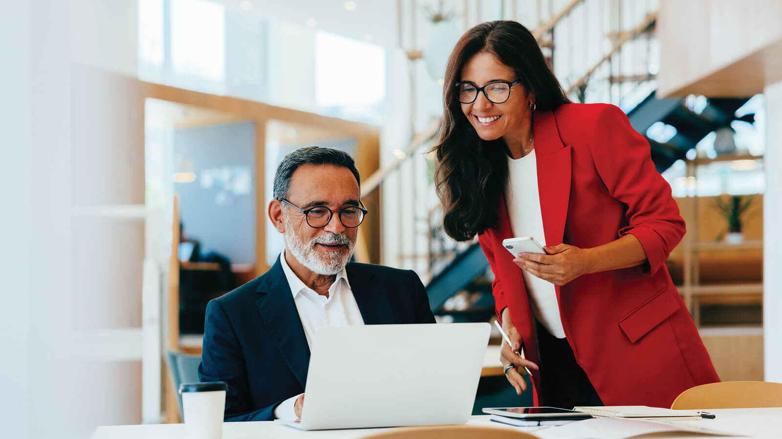 A business owner and next-generation family member discuss long-term business continuity and wealth transfer plans in their office.